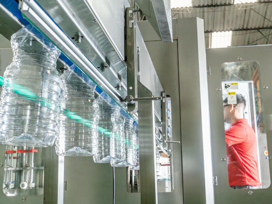 Botellas PET avanzando por una línea de llenado en planta